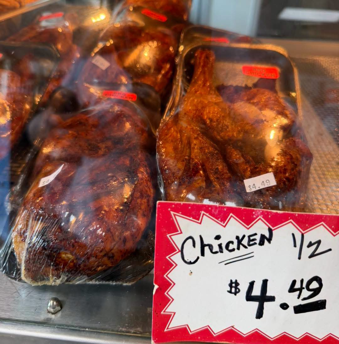 Packaged BBQ half chickens in the hot case with a hand-lettered $4.49 sign